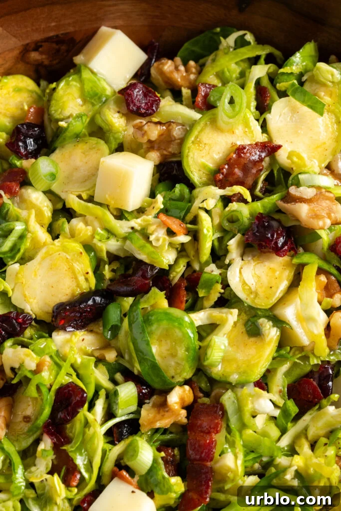 closeup shot on the tossed shaved brussels sprouts salad in a wooden bowl.