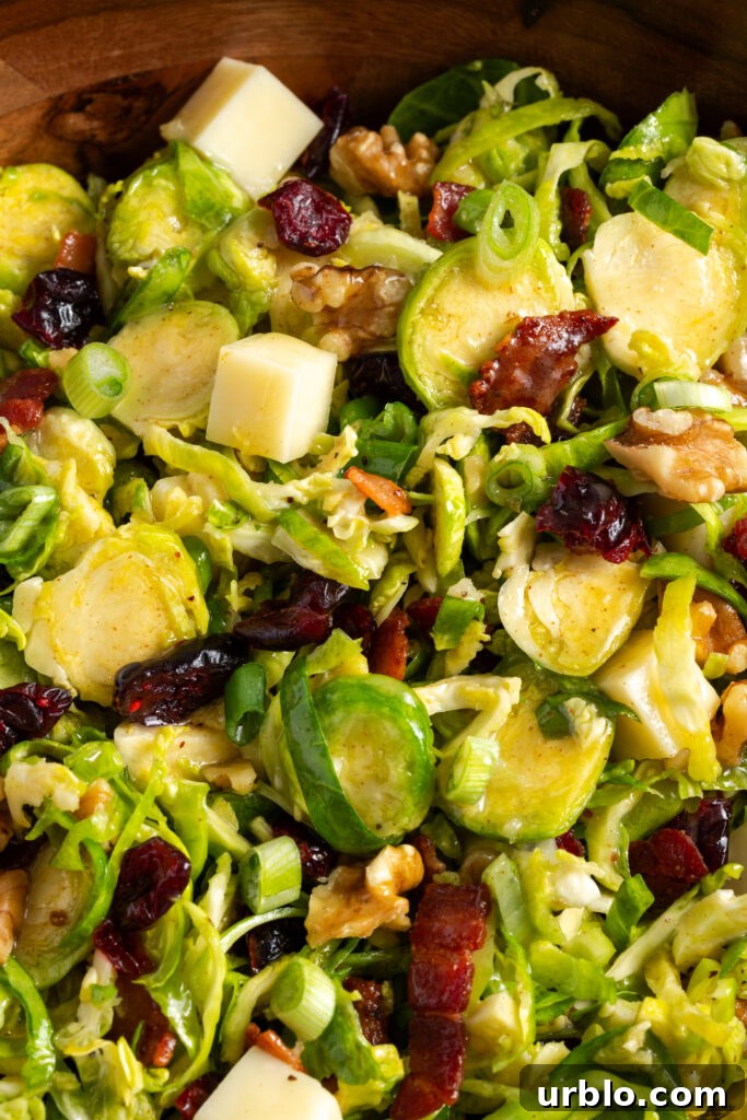closeup shot on the tossed shaved brussel sprouts salad in a wooden bowl.