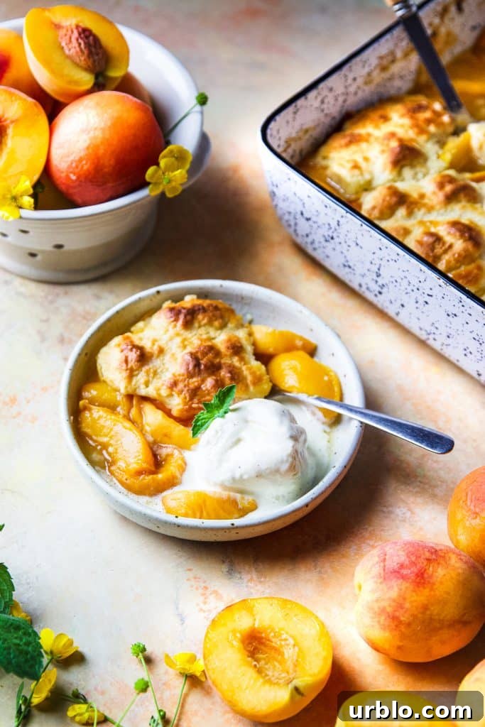 a serving of peach cobbler on a small plate with vanilla ice cream.