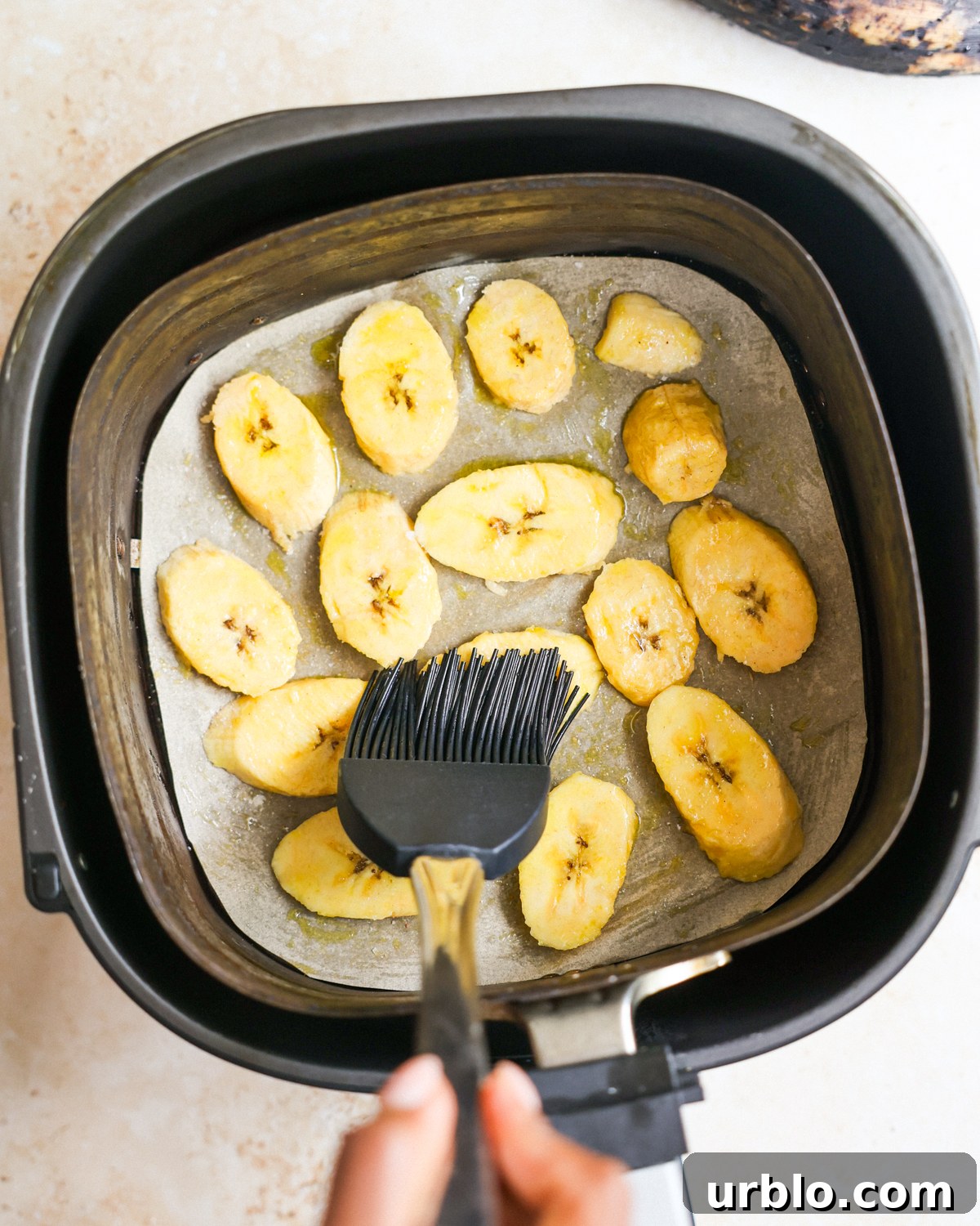 brushing oil on plantains