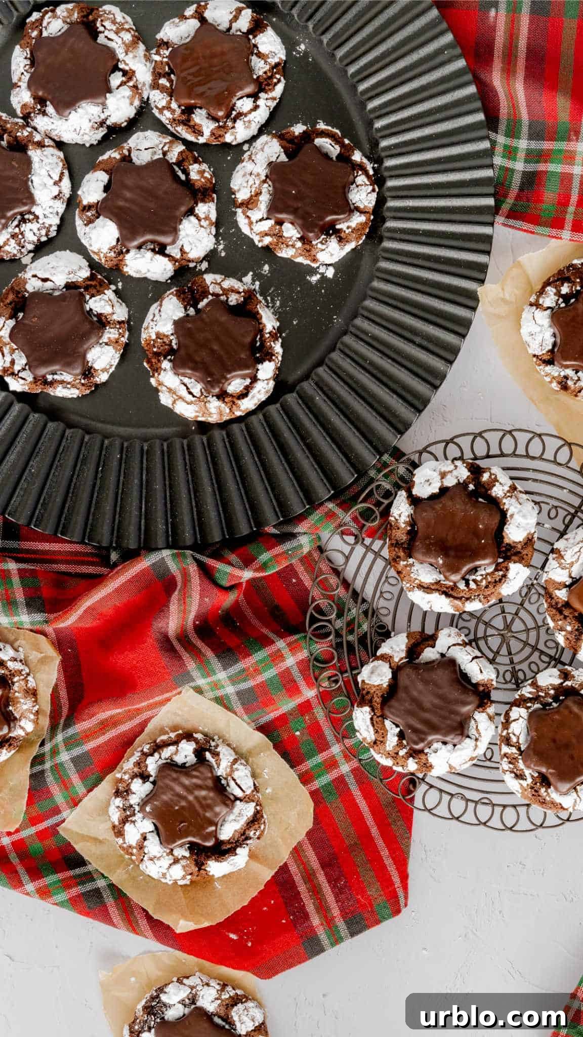 Bird's eye view of chocolate crinkle cookies with peppermint patties on a Christmas napkin.