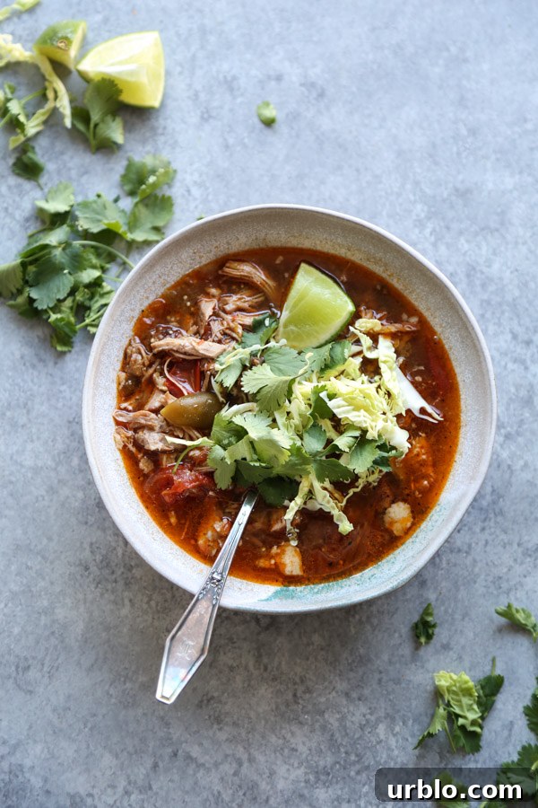 pozole rojo recipe in a bowl with cilantro and lime