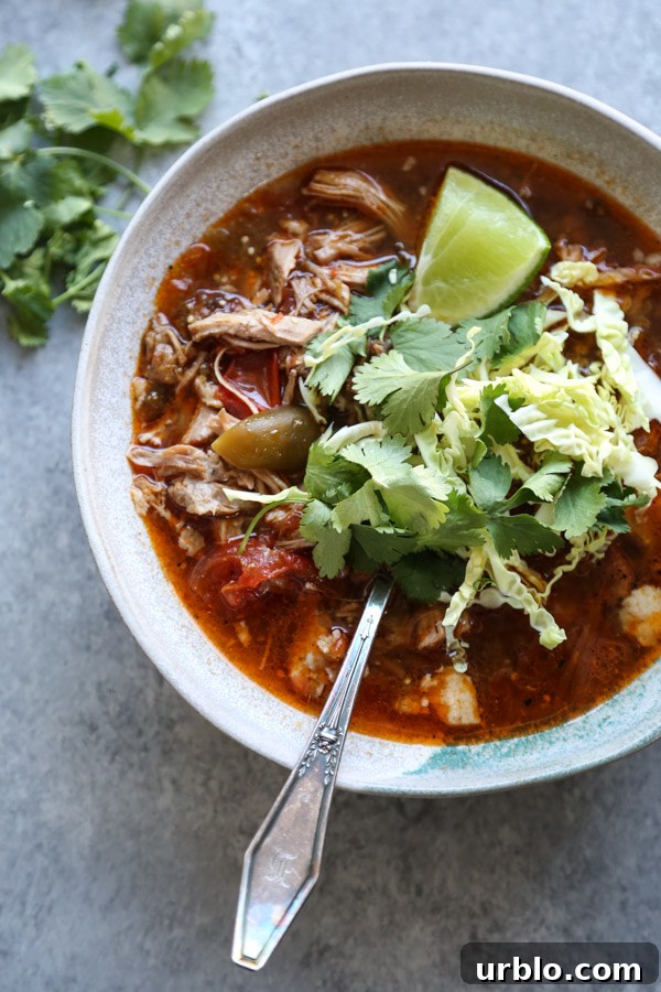 pozole rojo recipe in a bowl with cilantro and lime