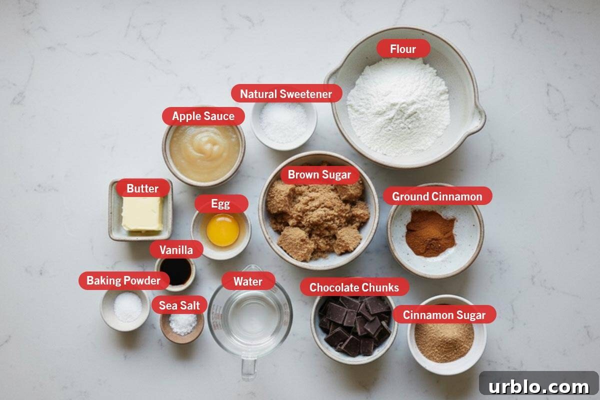 Top shot of ingredients: butter, apple sauce, natural sweetener, flour, baking powder, vanilla, egg, brown sugar, ground cinnamon, sea salt, water, chocolate chunks, cinnamon sugar.