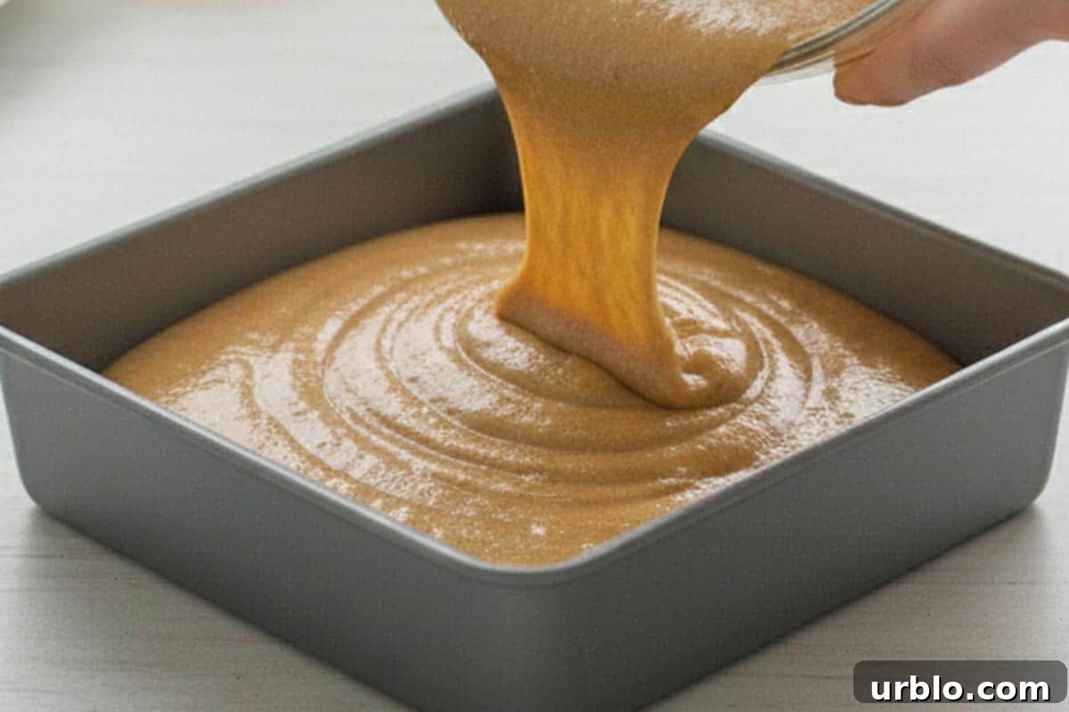 Pouring the batter into the prepared tray and spread it evenly.