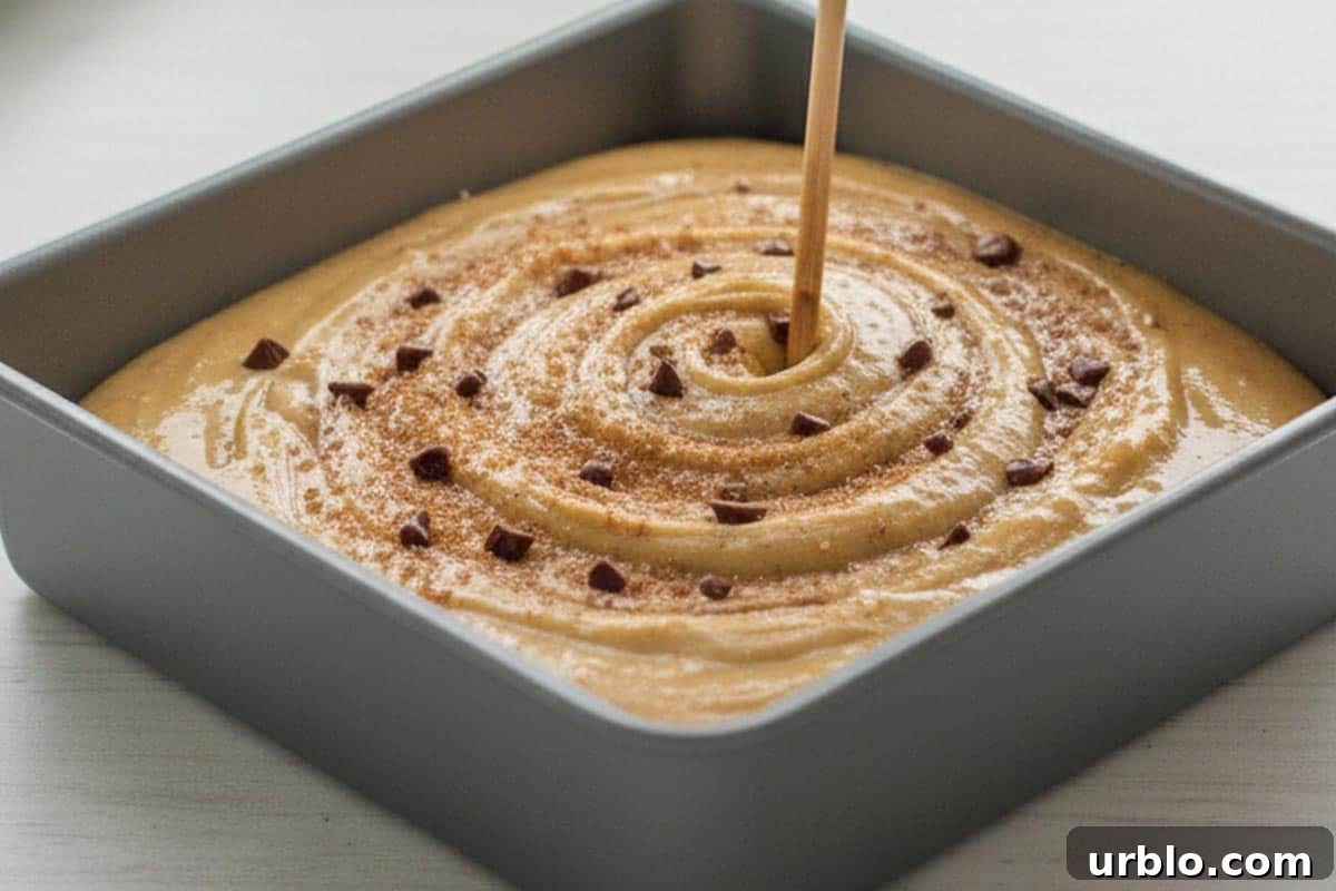Using a skewer to swirl the cinnamon sugar and chocolate into the batter to make a ripple.
