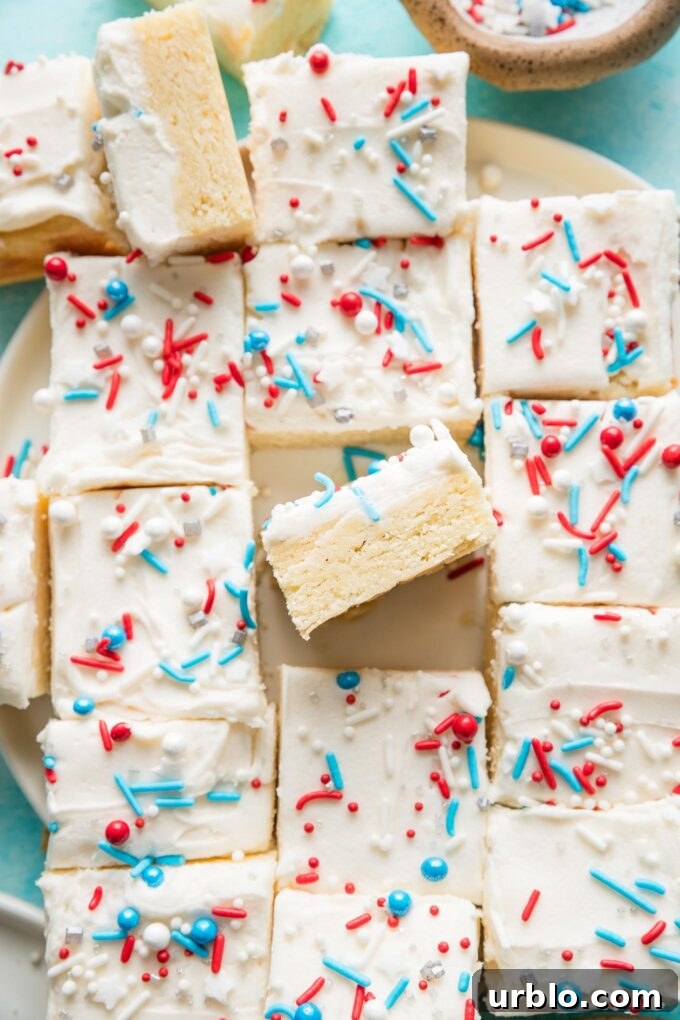 Patriotic Red, White & Blue Sugar Cookie Bars Recipe 2 Platter filled with frosted sugar cookie bars topped with red, white, and blue sprinkles