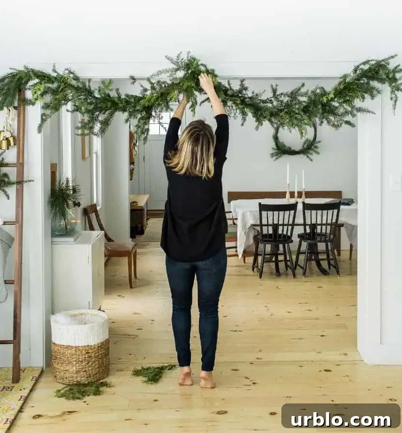 girl putting up garland over doorway