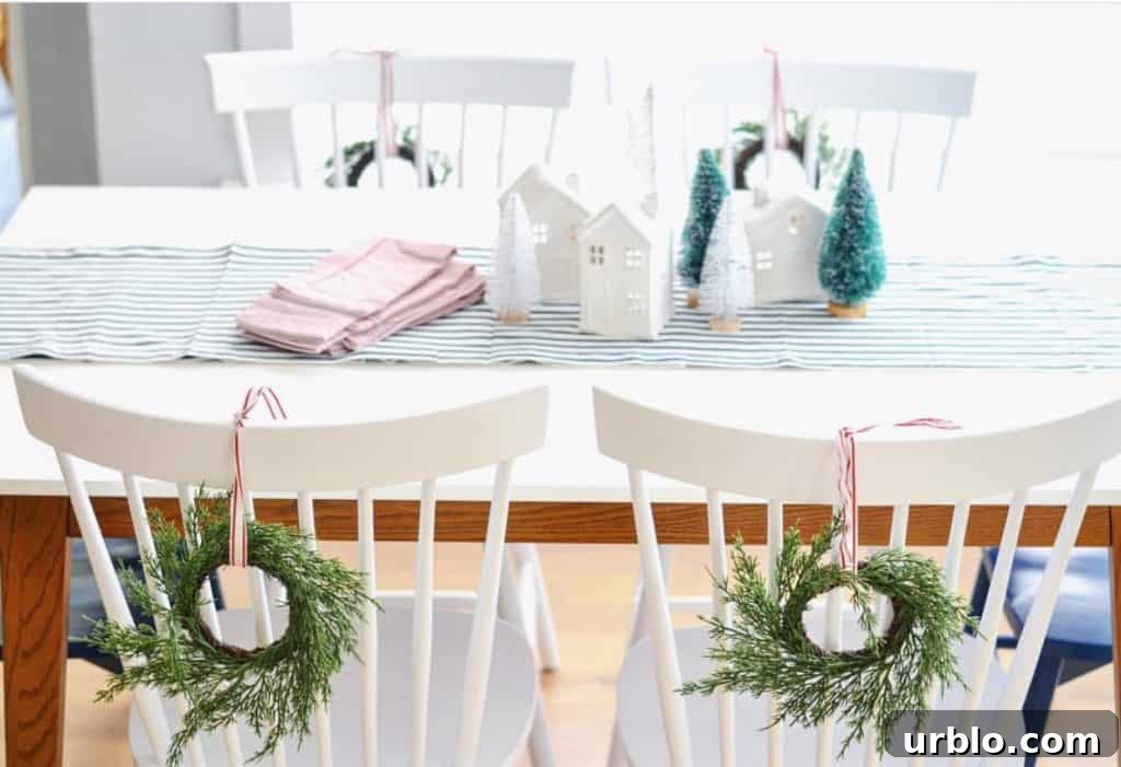 table decorated for Christmas with white chairs and wreaths on the back