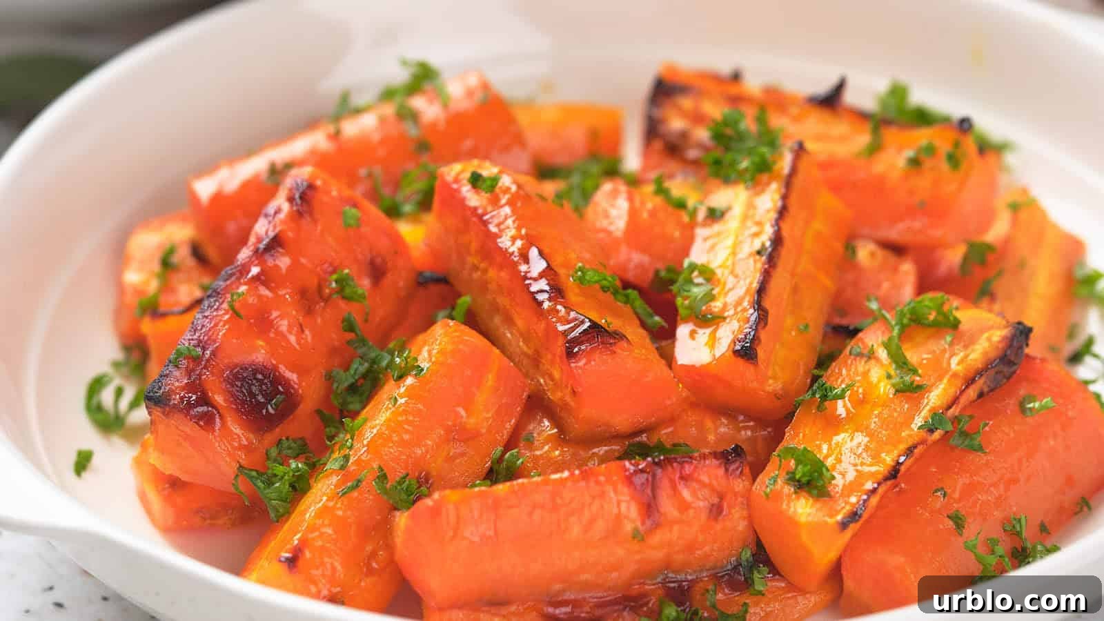 21 Crowd-Pleasing Potluck Recipes That Outshine Store-Bought Dishes 14 Honey glazed carrots in a white dish, garnished with chopped parsley.