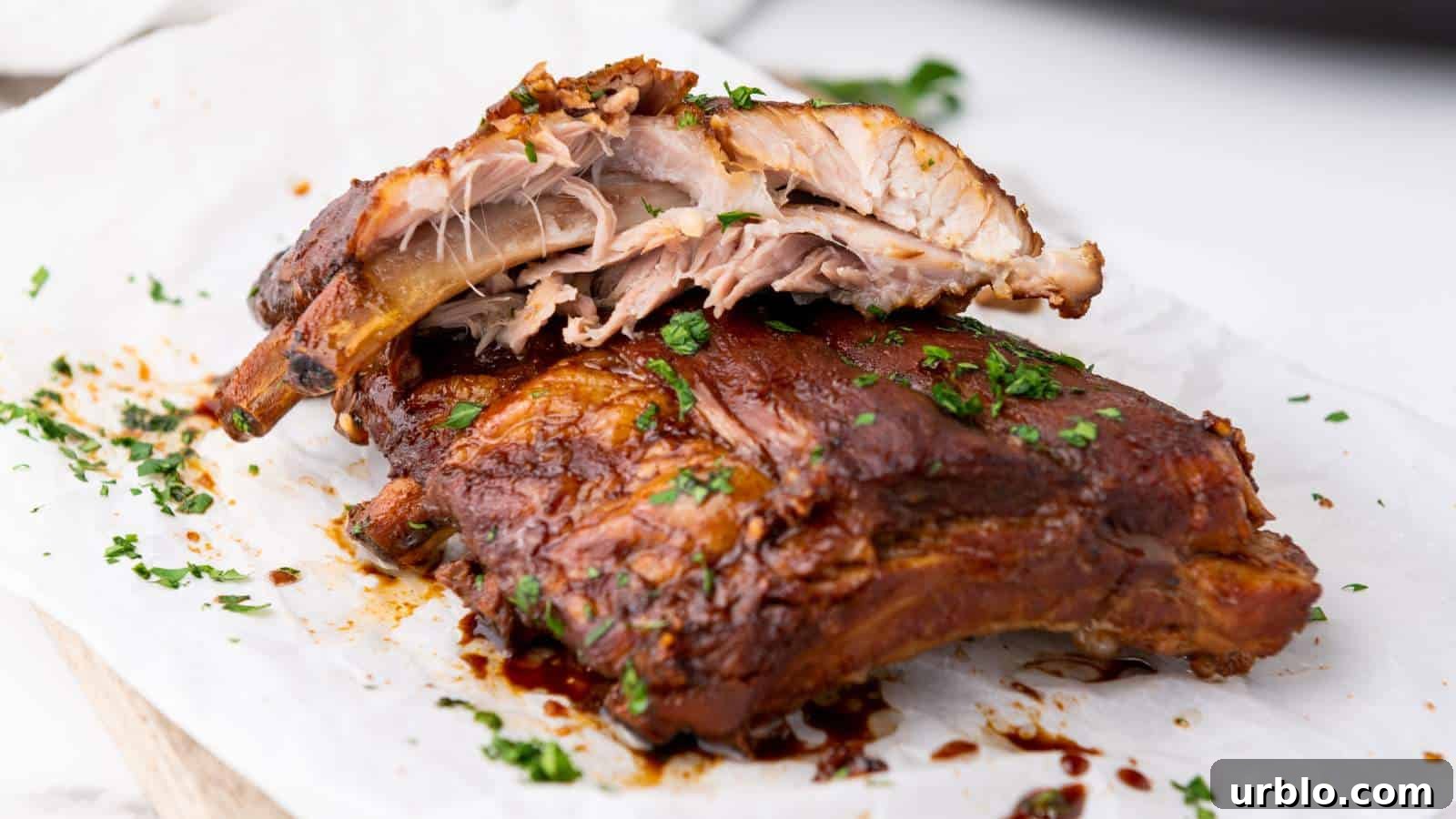 21 Crowd-Pleasing Potluck Recipes That Outshine Store-Bought Dishes 7 Close-up of cooked baby back ribs on parchment, garnished with chopped parsley.