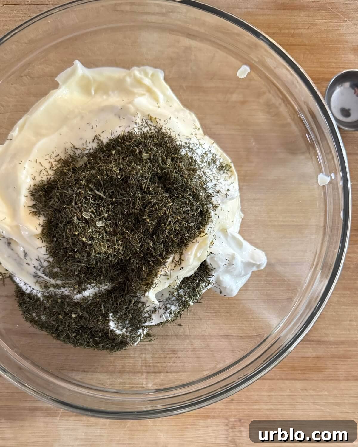 Quick 5-Minute Creamy Dill Dip Recipe for Parties and Snacks 6 Mayonnaise, sour cream and dried dill in a glass bowl.