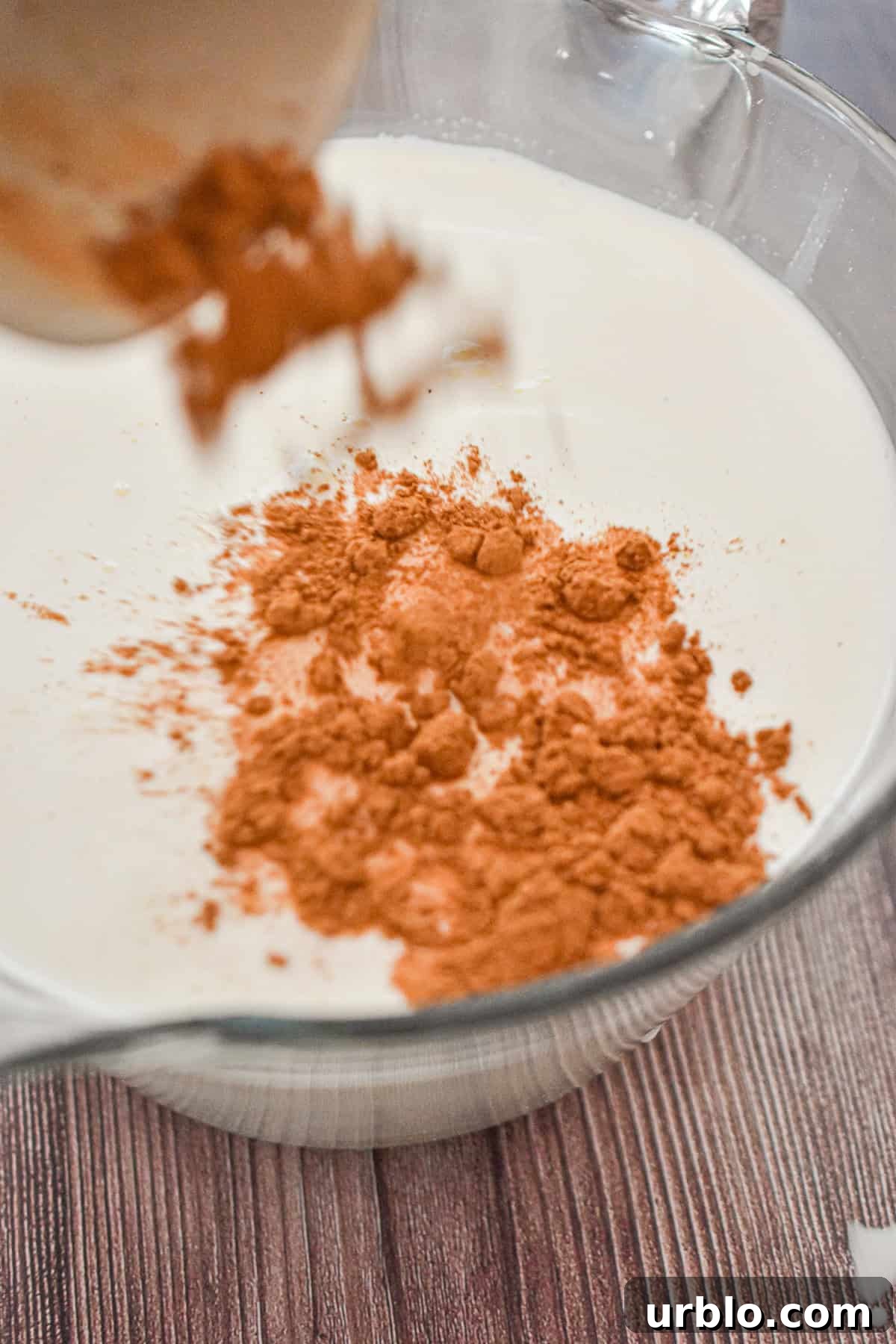 The cinnamon is added to the milk and cream mixture.
