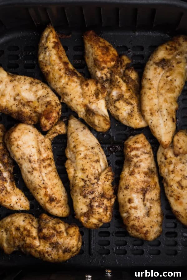 Reheated chicken tenders in the air fryer basket.