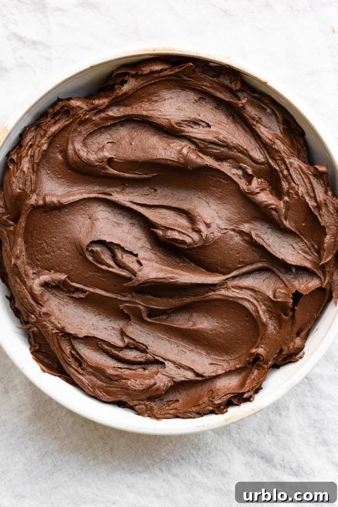 Silky Chocolate Ganache Buttercream Frosting Recipe 2 Overhead view of a bowl filled with dark chocolate buttercream frosting.
