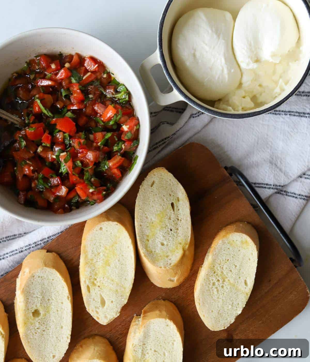 Bruschetta, french bread and burrata on serving dishes.