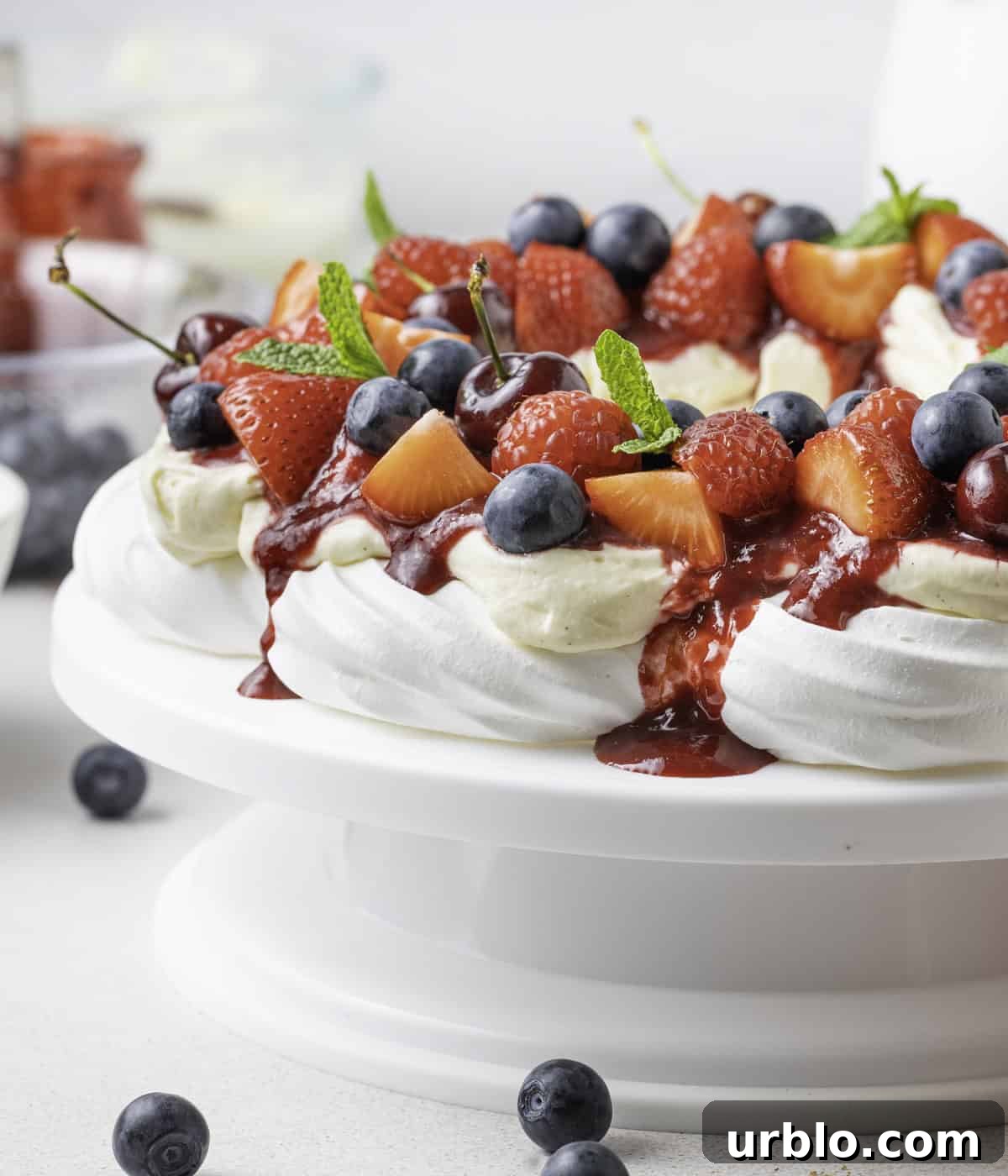 Close up on coulis dripping from the side of the pavlova.