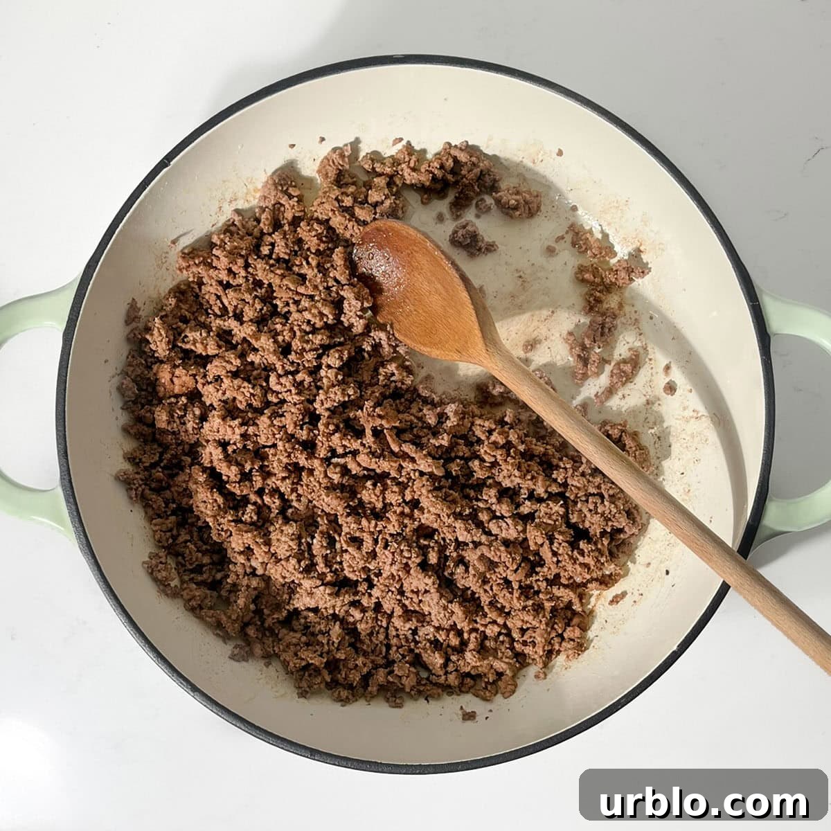 Browning the ground beef in a large frying pan.