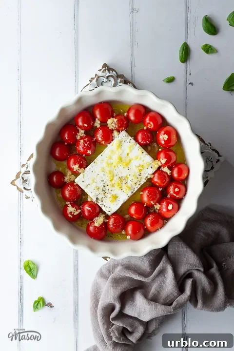 Unbaked feta pasta sauce in a dish on a decorative wooden board