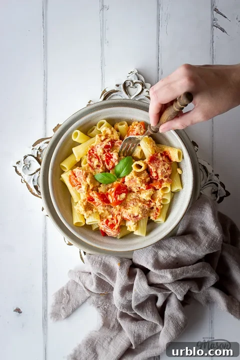 Tomato feta pasta being forked by someone
