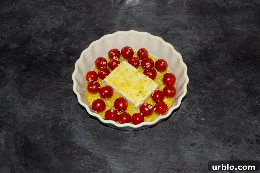 Tomatoes, a block of feta and garlic covered in olive oil in a dish