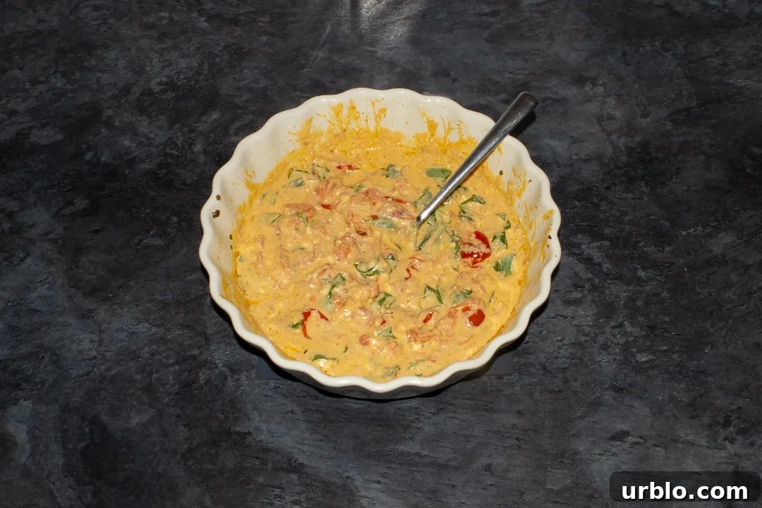 Baked feta tomato pasta sauce in an ovenproof dish with basil stirred through it.