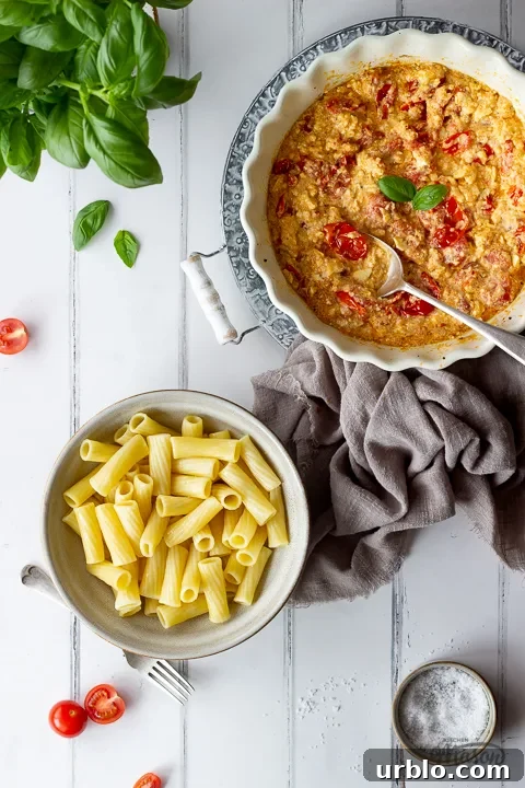 A bowl of cooked pasta and a dish of tomato feta pasta sauce