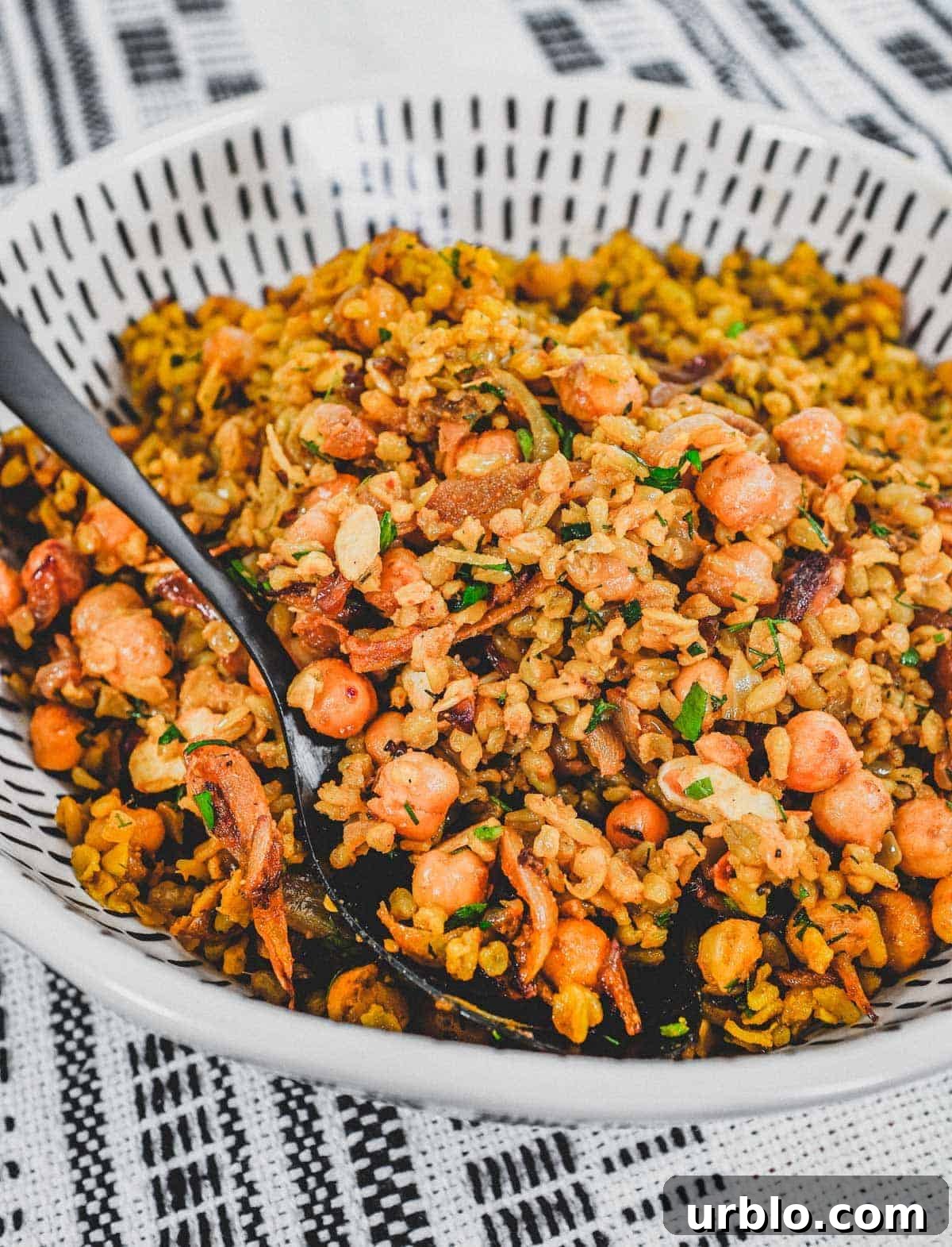 Freekeh cooked with onion and chickpeas in a large serving bowl