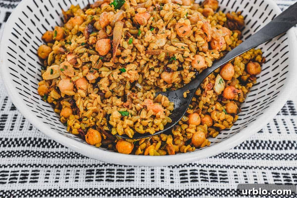 Freekeh cooked with onion and chickpeas in a large serving bowl