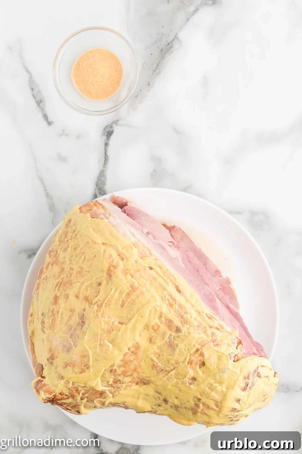 Rubbing Dijon Mustard on ham