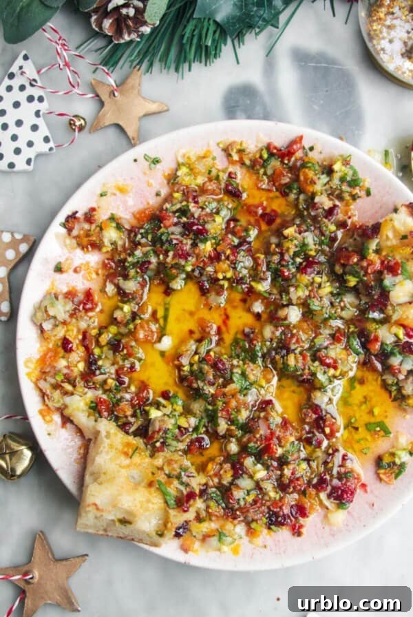 Festive dipping oil in a small pink plate on a grey surface.