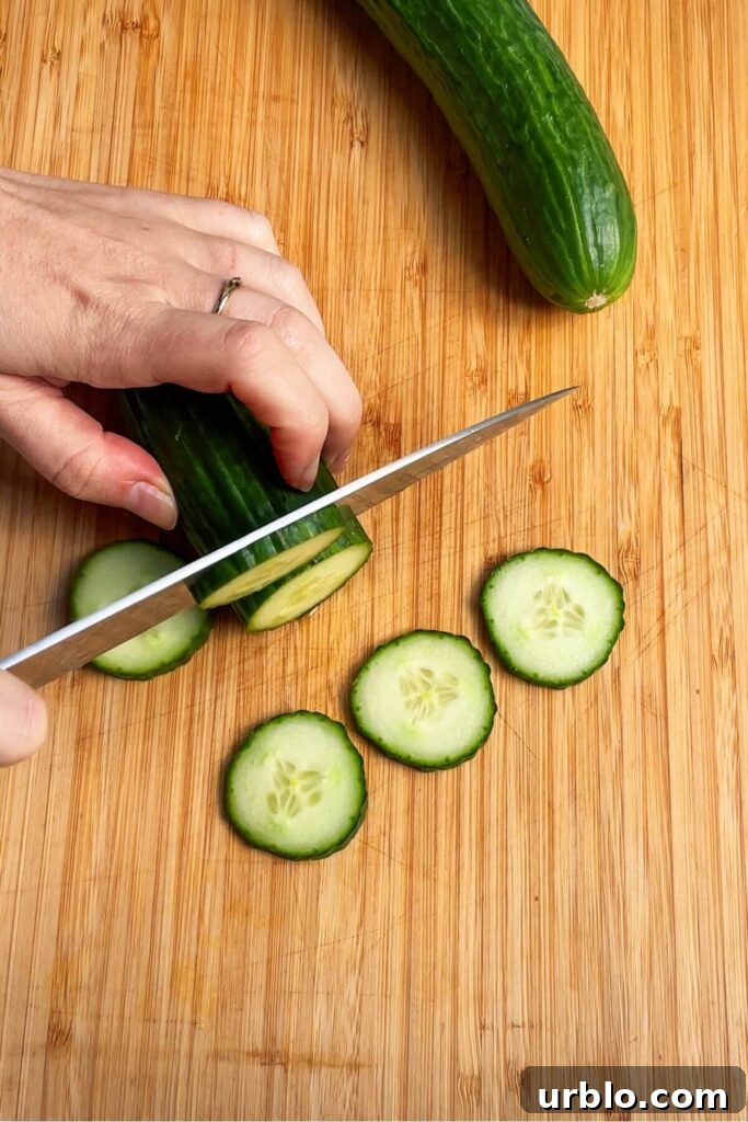 Slicing cucumber on a wooden board.