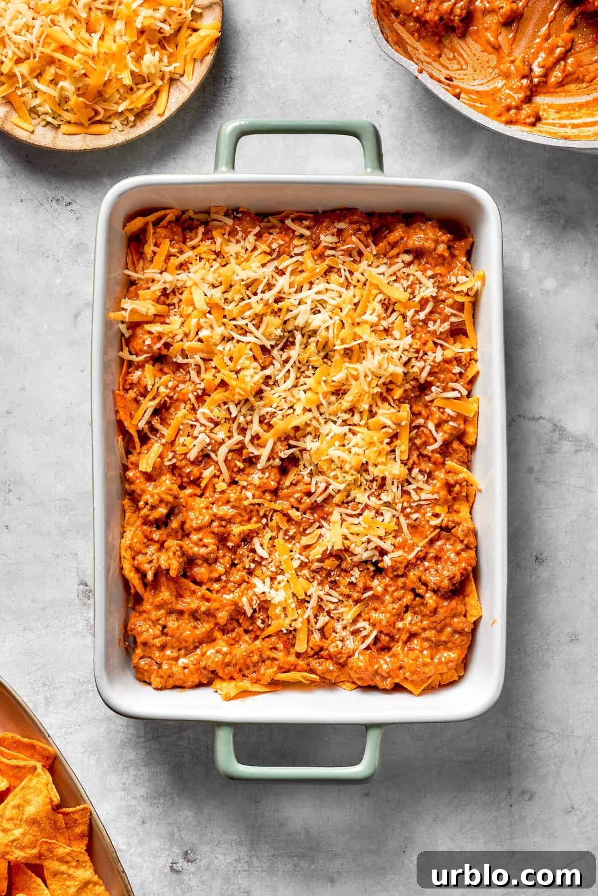 Shredded cheese in added to a Dorito casserole.