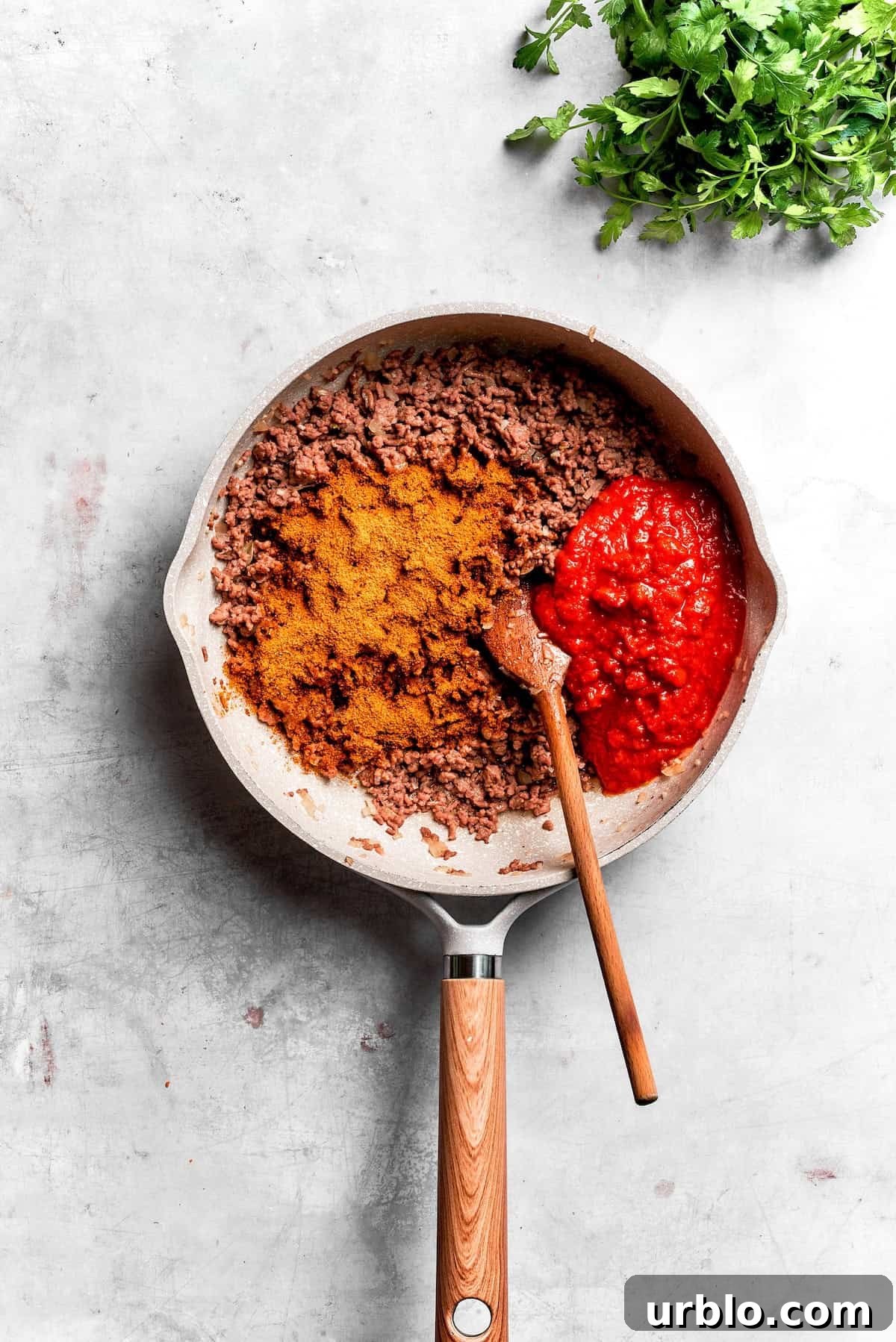 Beef browns in a skillet with taco seasoning.
