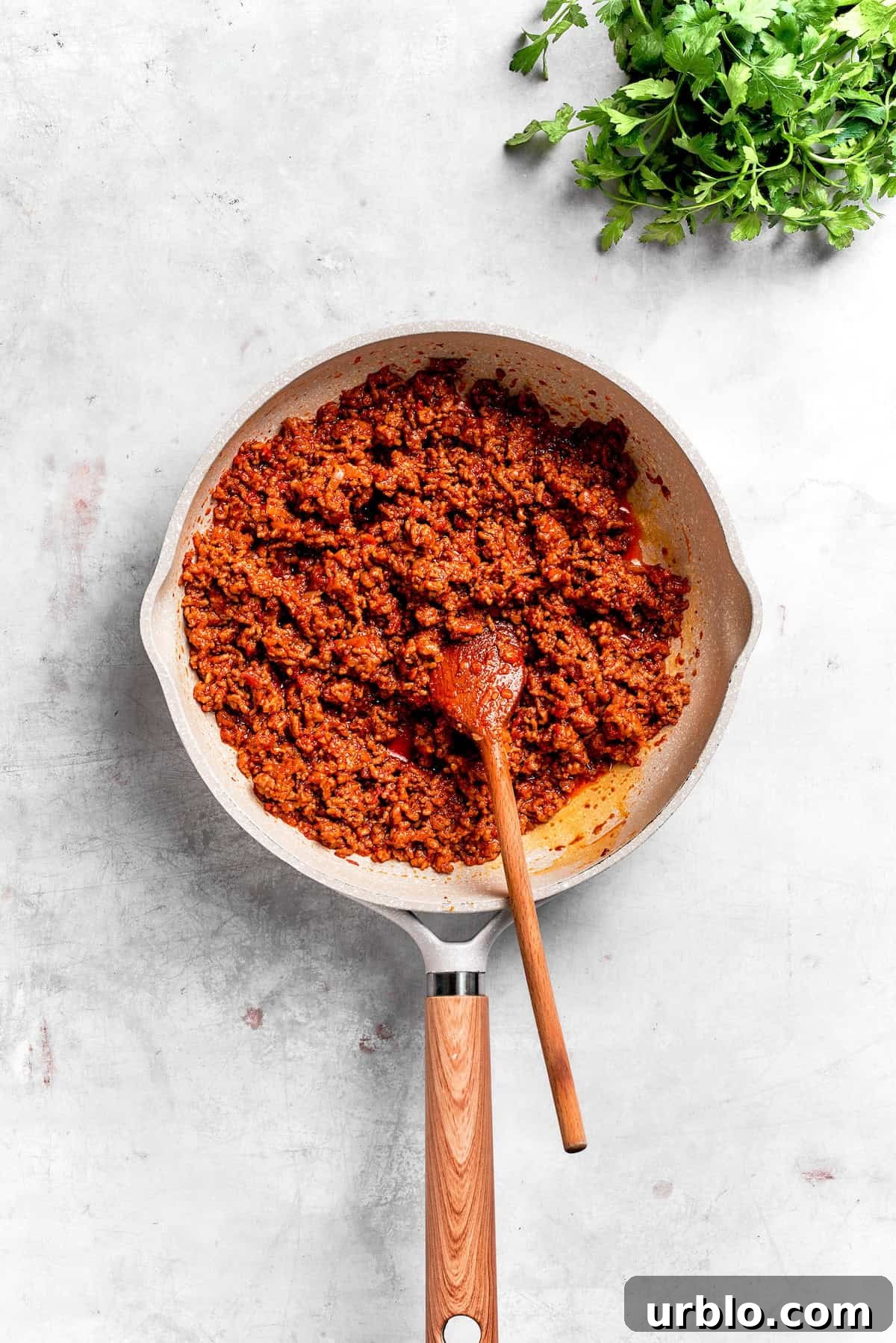 The beef filling mix for Dorito casserole in a skillet.