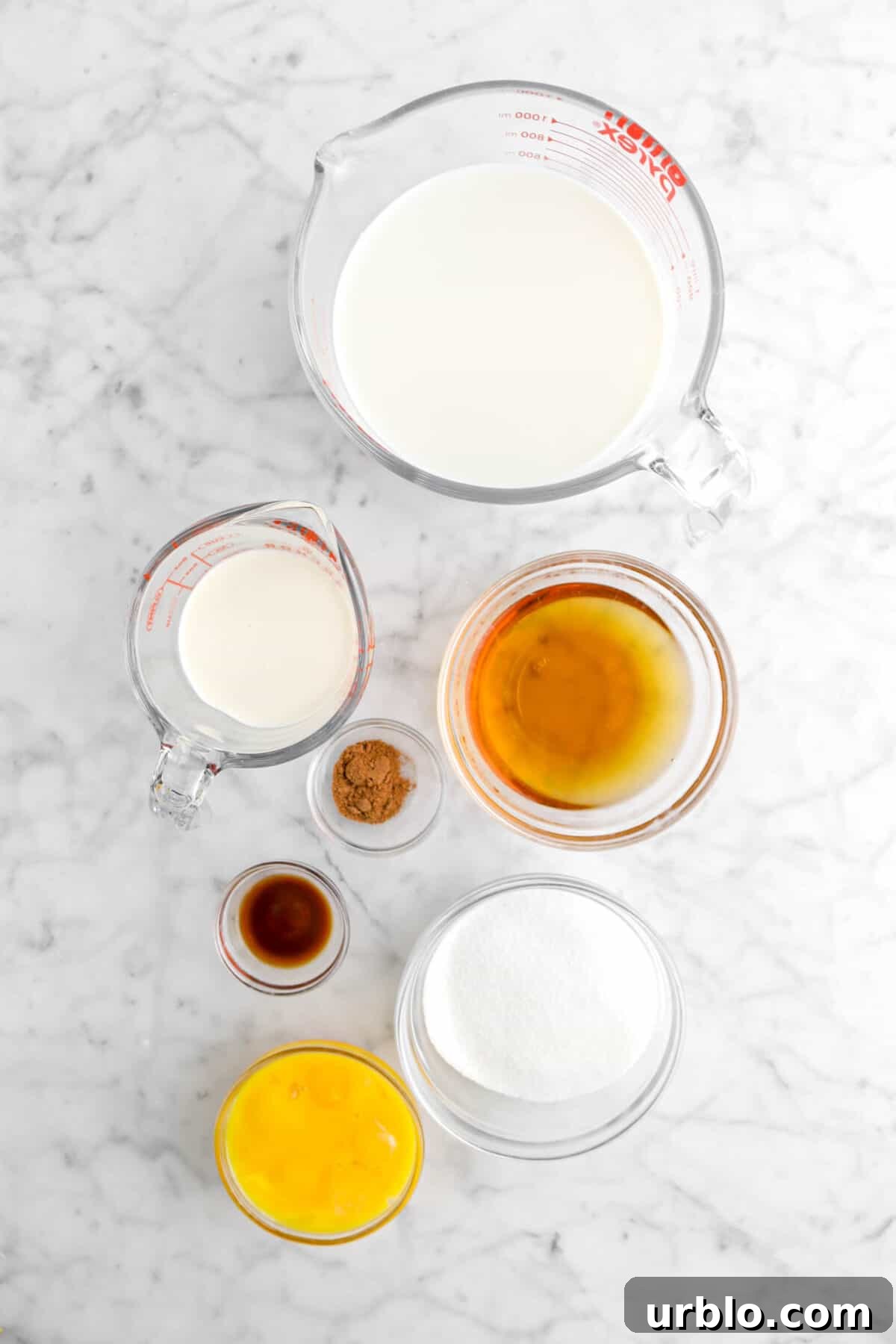 heavy cream, whole milk, bourbon, nutmeg, vanilla, sugar, and egg yolks on marble counter