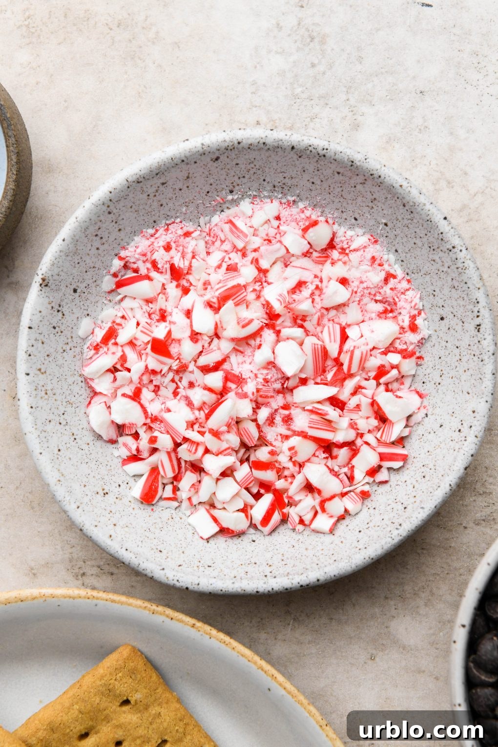 Ingredients images for chocolate peppermint covered graham crackers: Small bowl of crushed candy canes.