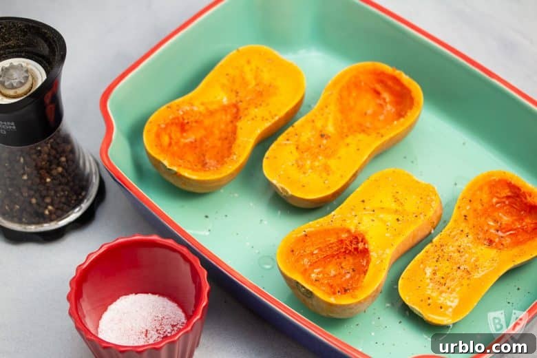 Baking dish with 4 honeynut squash halves ready to roast