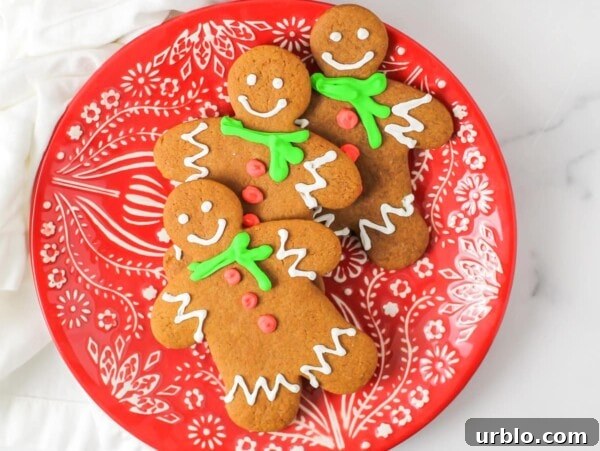 The Best Gingerbread cookie recipe - decorated and stacked on a Christmas plate.