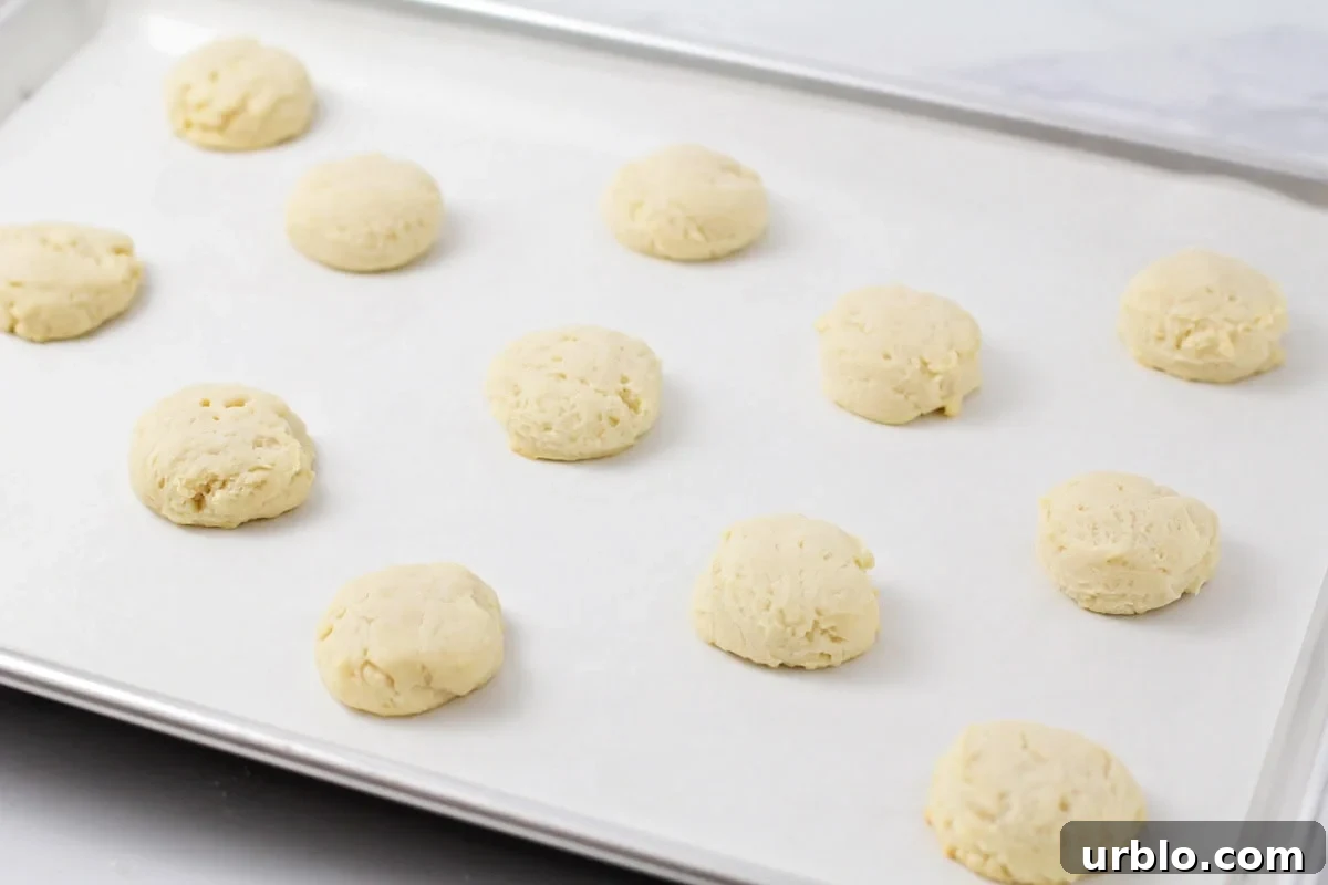 Several baked cookies on a lined baking sheet.