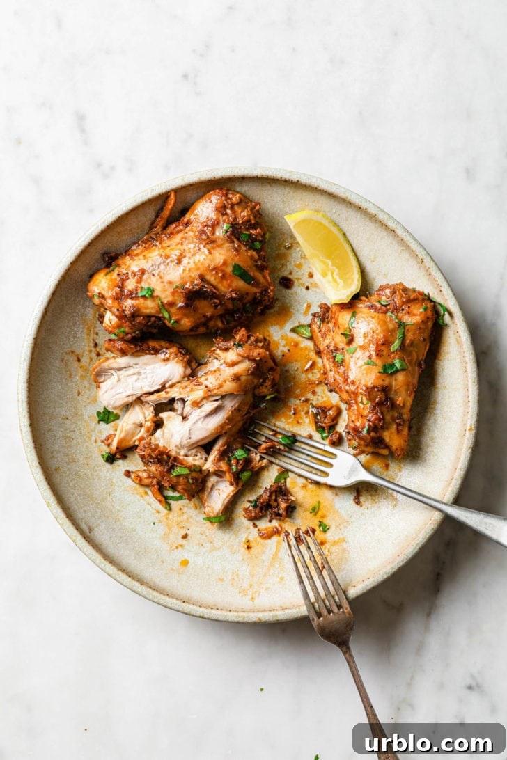 A plate of half-eaten chicken thighs with silver forks.