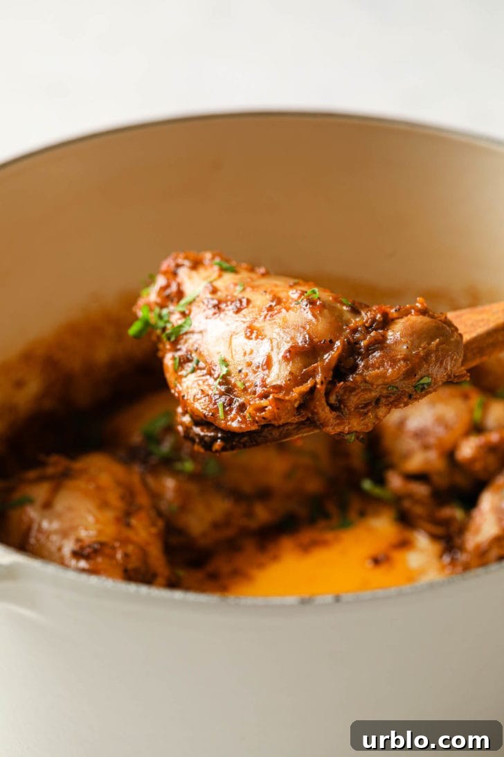 Lifting a piece of chicken with a wooden spoon.