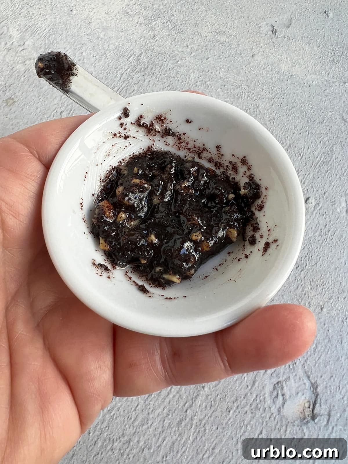 Walnuts mixed into a small amount of the filling in a small white bowl.