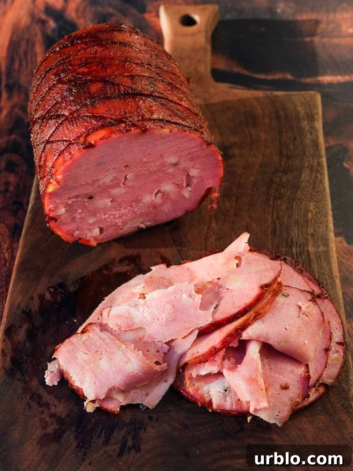 Smoked mortadella and slices of mortadella on a cutting board