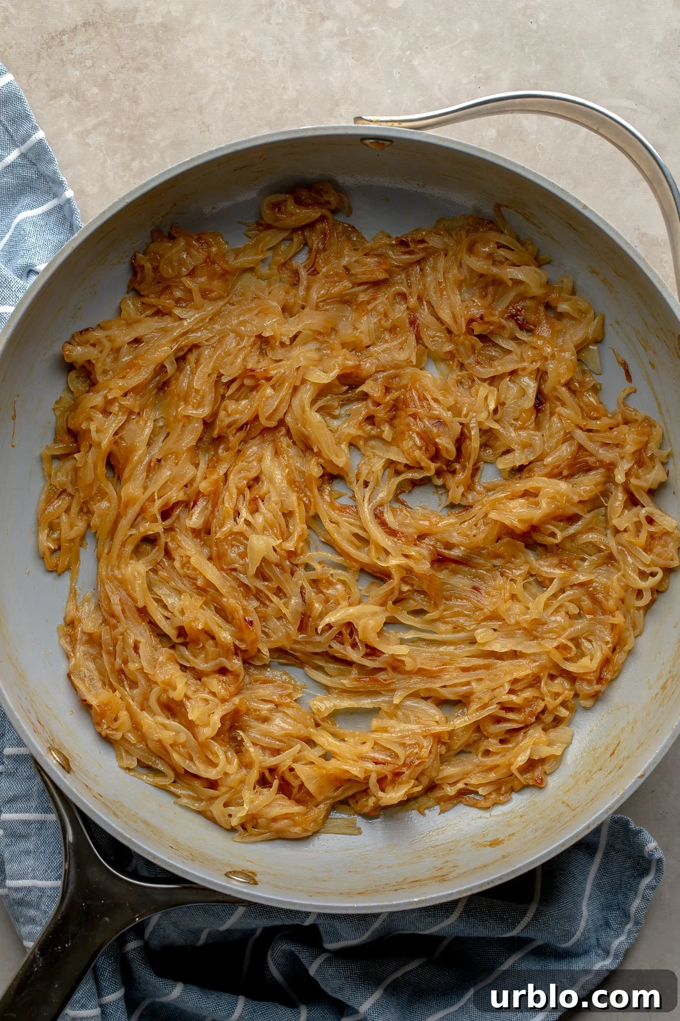 overhead view of caramelized onions in a large skillet.