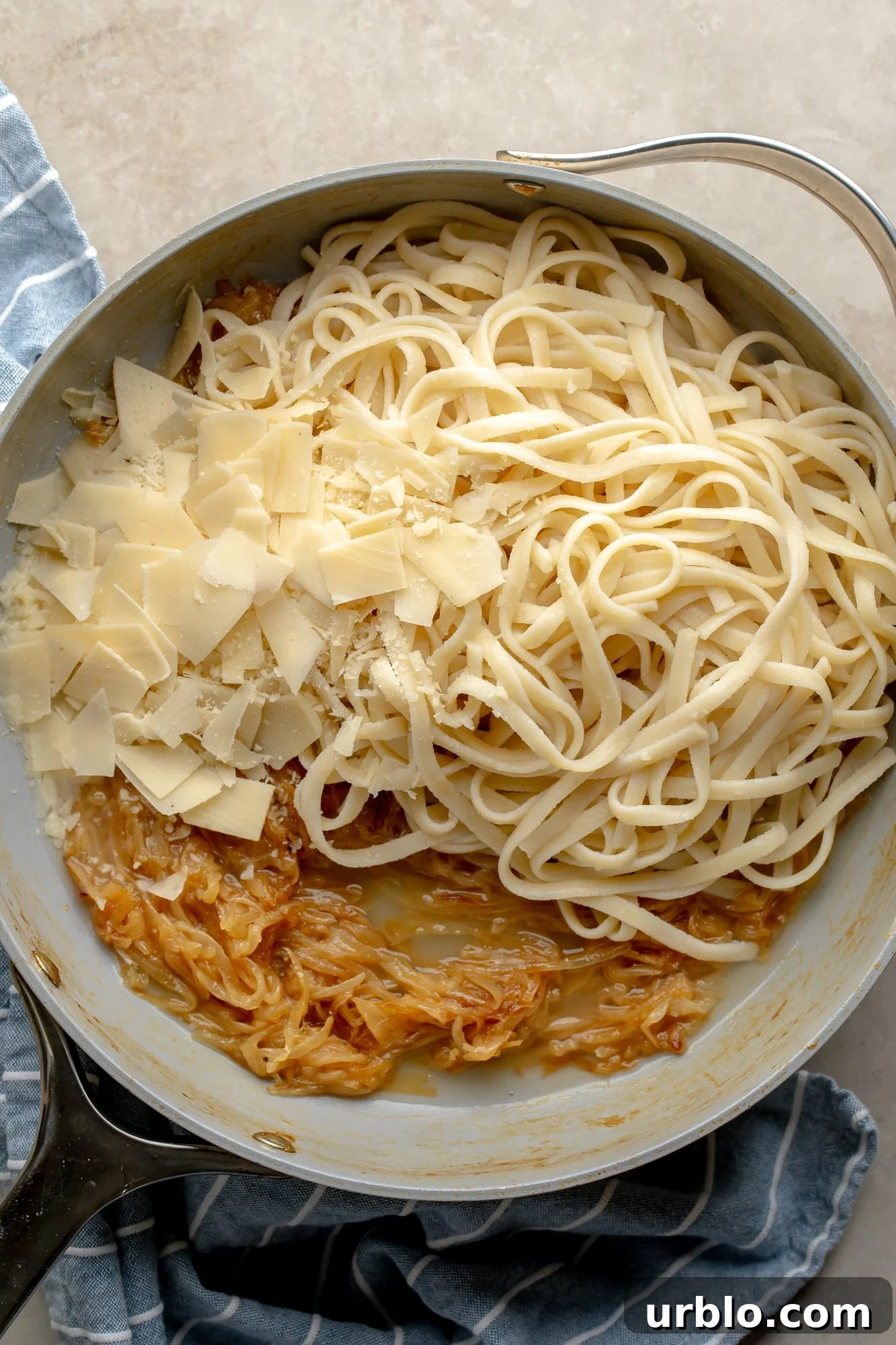 overhead view of a skillet full of the ingredients for vegan caramelized onion pasta.