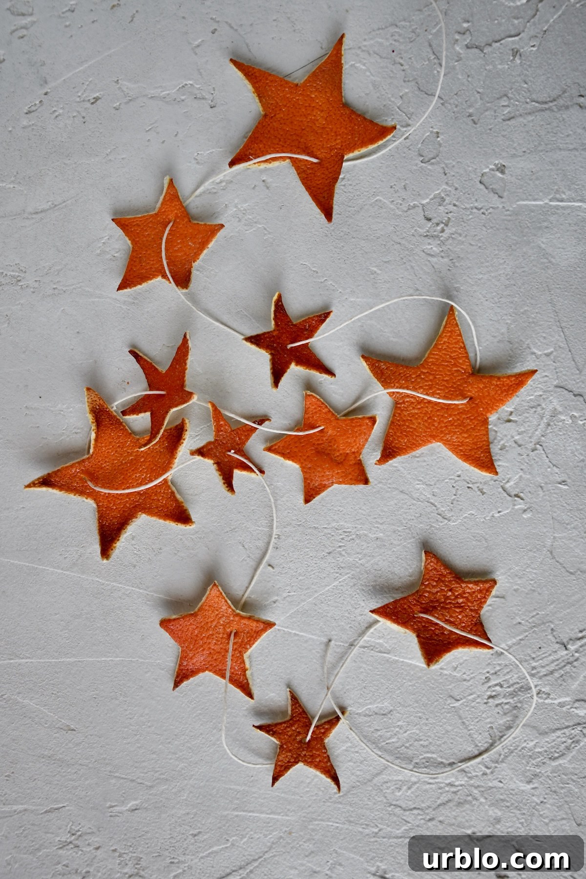 Orange Peel Star Garland strung up on twine, laid out and ready to be placed on a tree.