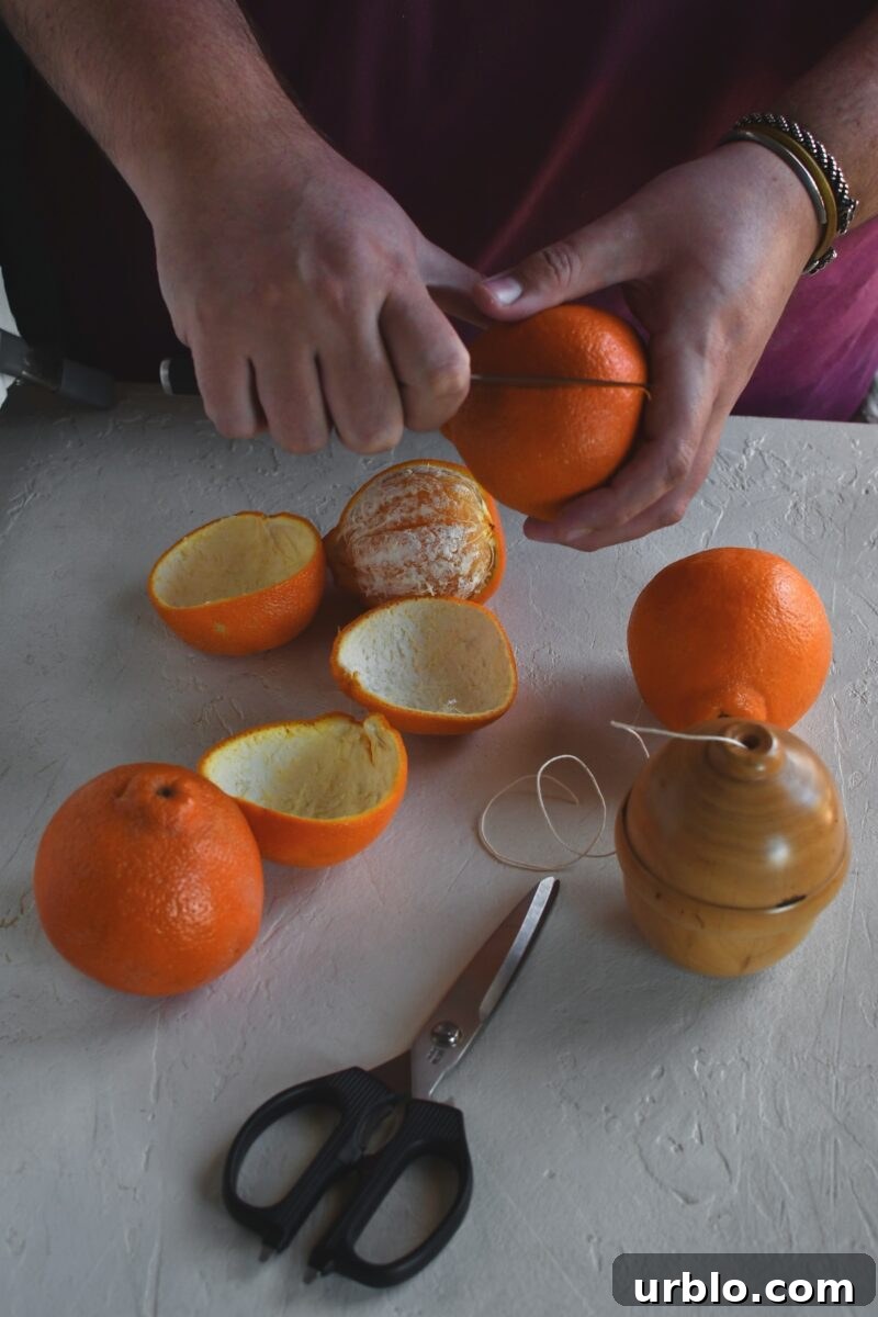 Gently slicing an orange to remove the peel only.