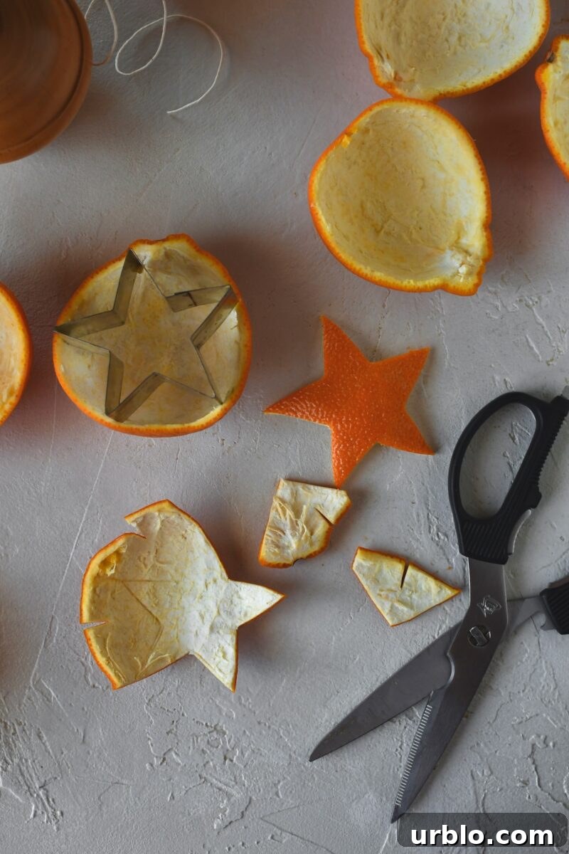 Using a star cookie cutter to score the orange peel, then using scissors to cut them out.