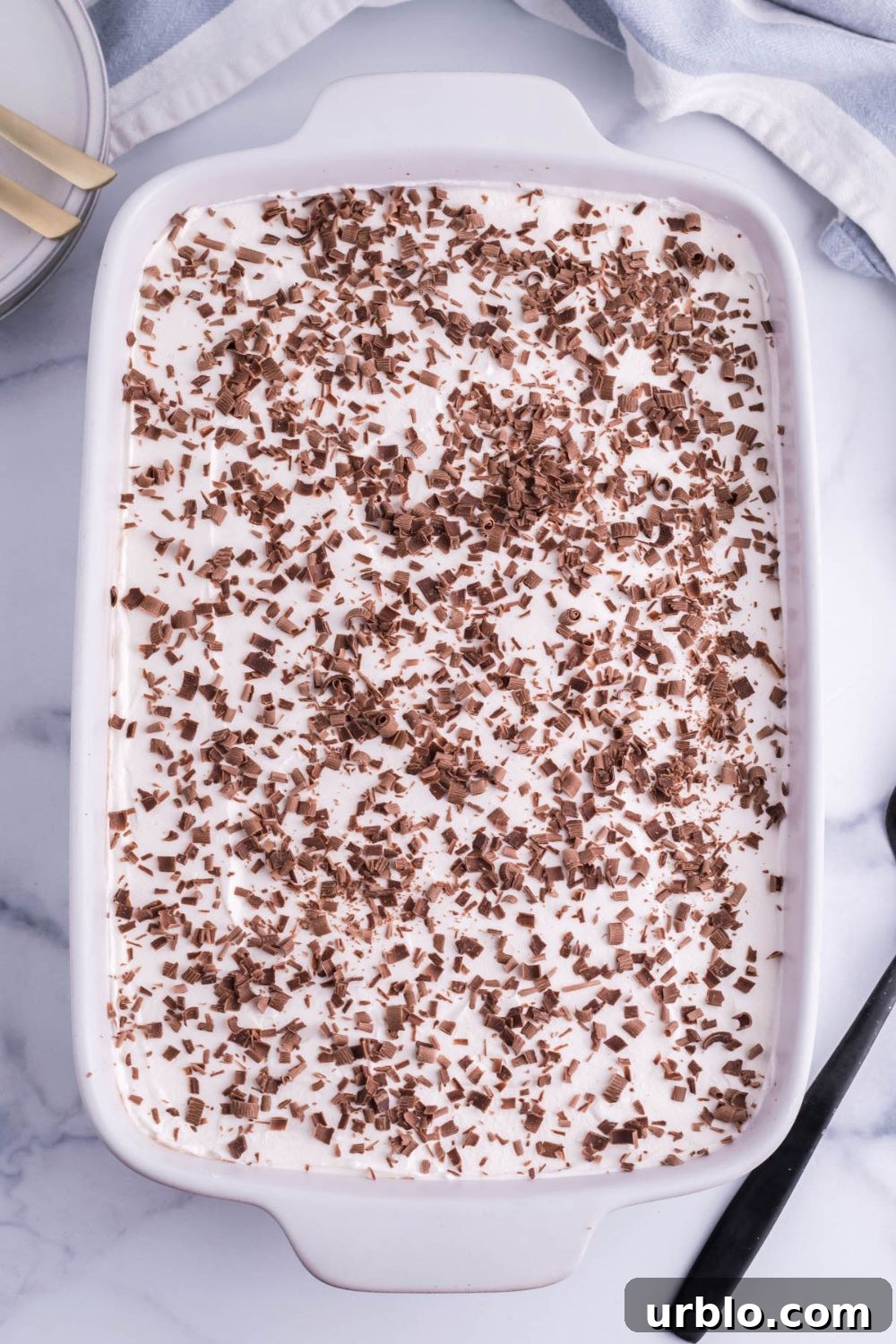 chocolate shavings topped on french silk pie brownies in a 9x13 baking dish on a marble table